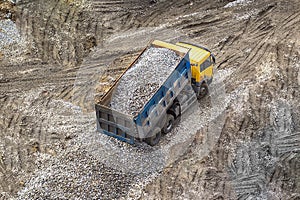 Truck unloads shipping or transportation rubble rock gravel to the ground