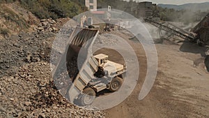 Truck unloads stones in a pile.