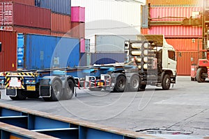 The truck is waiting for the container. in the container yard