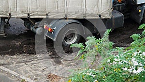 Truck wheel slips in the dirty. Slow motion. Powerful Big Truck wheel slips in the mud. Heavy-Duty Truck. Automotive trailer