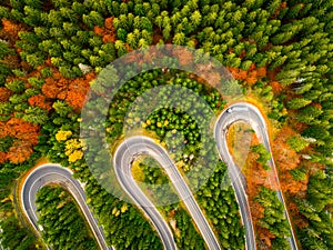 Truck winding up its way on a curvy road through autumn colored