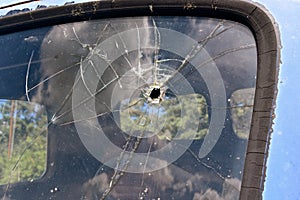 Truck window with a shattered bullet holed window