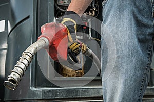Trucker with Diesel Pump Nozzle in His Hand