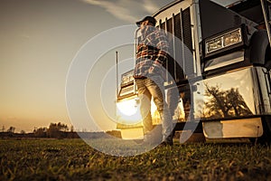 Trucker in Front of His Semi Truck During Sunset