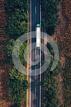 Trucking and freight transport logistic concept, aerial shot of semi-truck on highway from drone pov