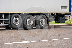 Trucks with containers in the parking lot along the highway against the background of clouds. The concept of logistics, transport