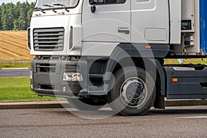 Trucks with containers in the parking lot along the highway against the background of clouds. The concept of logistics, transport