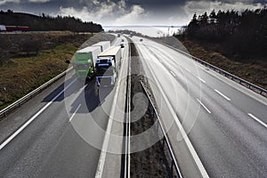 Trucks deriving on scenic highway at sunset