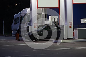 Trucks at a gas station at night