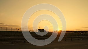 Trucks on a highway road at sunset. Transportation delivery cars against sunset sky slow motion