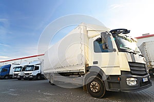 Trucks are loaded with goods at the depot in a shipping company