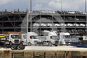 Trucks and luxury cars await export from docks UK