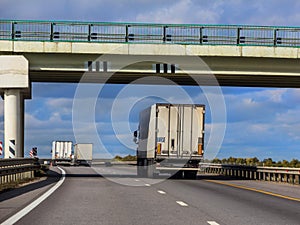 Trucks move under a viaduck