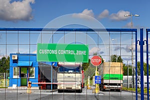 Trucks pass through checkpoint of customs logistics terminal.