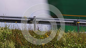 Trucks race past a freeway guardrail