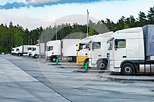 Trucks in a row with containers in the parking lot near forest , Logistic and Transport concept