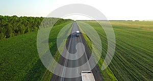 Trucks with a semi-trailer drive along the highway, aerial view.