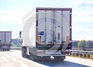 Trucks with semitrailers move along a country road