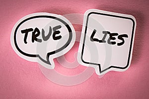 True and Lies concept. White speech bubbles with text on a pink background