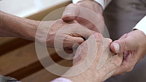 True love through hard times, man holding old female hands, support and care photo