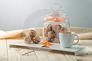 Truffle balls with orange chocolate on the saucer next to the jar of candy and a Cup of coffee.