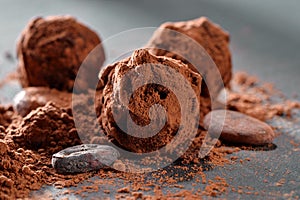 Truffle chocolate candy and powder close-up on black slate plate