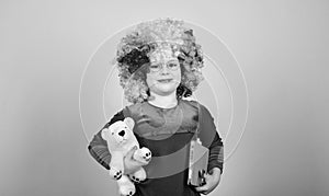 Truly happy childhood. Girl cute playful child wear curly rainbow wig. Life is fun. Happy little child girl
