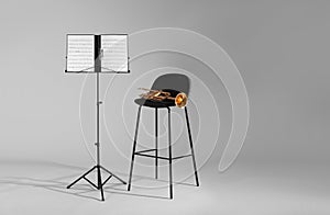 Trumpet, chair and note stand with music sheets on grey background.
