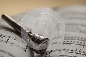 Trumpet mouthpiece on sheet music book photo