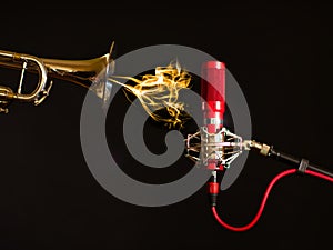 A trumpet, ribbon microphone and a black background.