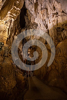 Trung Trung Cave Cat Ba Vietnam Girl Tourist admires beautiful Stalactite formations