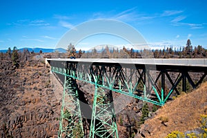 Truss metal bridge with tapered supports through deep rocky ravi photo