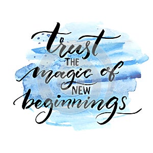 Trust the magic of new beginnings. Inspiration saying. Vector brush calligraphy on blue watercolor strokes. Encouraging