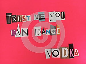 Trust me you can dance vodka written on scraps of magazine paper on a pink background