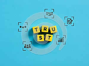 Trust, partnership and business. Organizational trust. The word trust on yellow cubes with business symbols