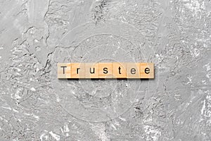 Trustee word written on wood block. trustee text on table, concept photo