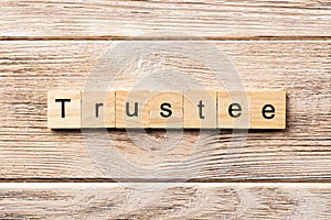 Trustee word written on wood block. trustee text on table, concept photo