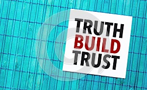 truth build trust word on torn paper with blue wooden background