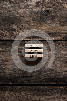 Truth Builds Trust sign written on three stacked wooden pegs