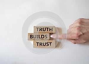 Truth builds trust symbol. Concept word Truth builds trust on wooden blocks. Businessman hand. Beautiful white background.