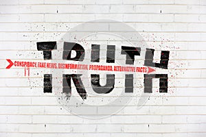 Truth destroyed with an arrow of conspiracy, fake news, disinformation, propaganda, alternative facts, painted on old white wall