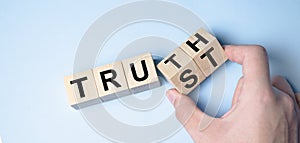 Truth instead of trust. Hand turns dice and changes the word Trust to Truth