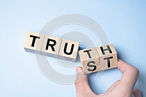 Truth instead of trust. Hand turns dice and changes the word Trust to Truth