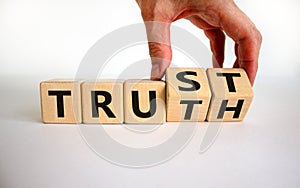 Truth or trust symbol. Male hand turns wooden cubes and changes the word `Truth` to `Trust`. Beautiful white background. Busin