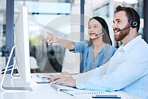 Try doing it this way instead. two call centre agents working together on a computer in an office.