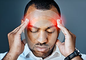 Try not to let the stress overpower your success. Studio shot of a young businessman suffering with a headache against a