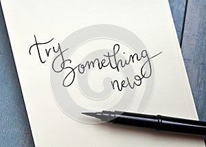 TRY SOMETHING NEW hand-lettered in notepad with brush pen