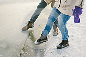 Trying the danger of the foot, testing the thin ice near the shore. A pair of lovers walk with a walk along a frozen lake to press