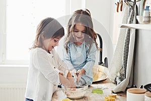 Trying to recreate what they were taught. Preschool friends learning how to cook with flour in the white kitchen