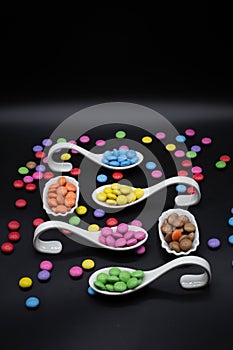 tryspoon for bithday buffet or party with smarties in many different colors on black background